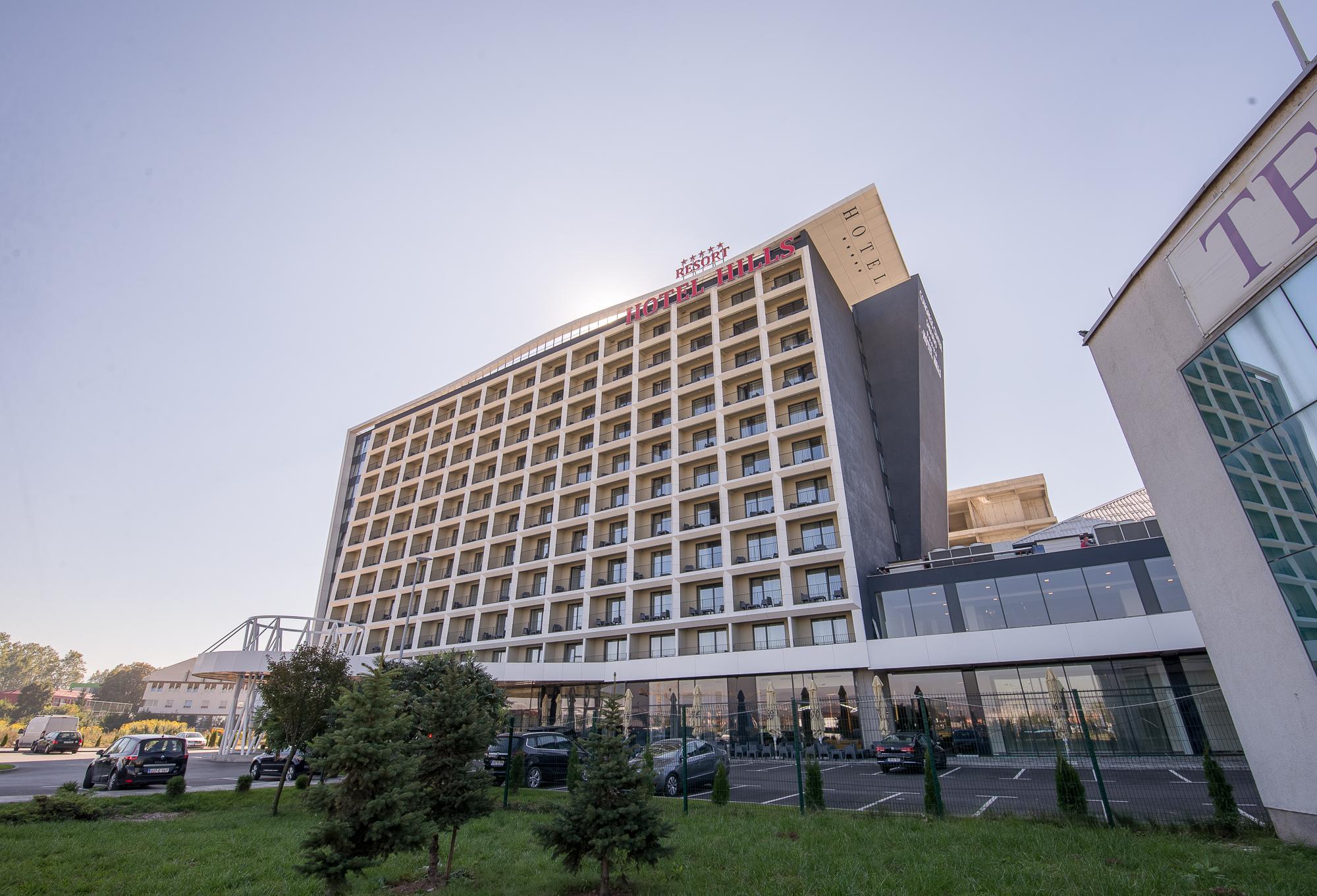Hotel Hills Sarajevo Congress & Thermal Spa Resort Ilidža Ngoại thất bức ảnh The photo shows a modern hotel building with multiple floors and a contemporary design. The structure features large windows arranged in a grid pattern and a prominent entrance area at the bottom. There are green areas, possibly with trees or landsca